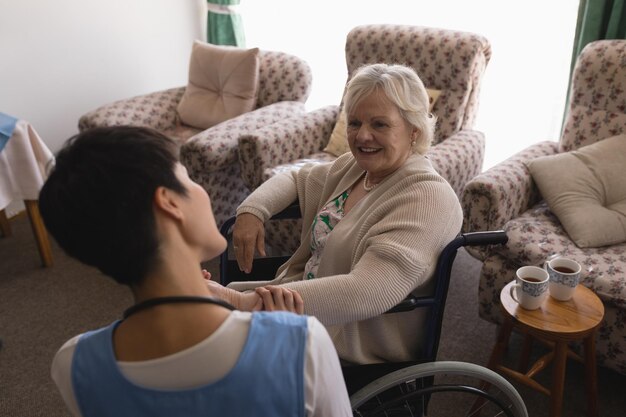 Photo une médecin interagissant avec une femme âgée handicapée dans le salon