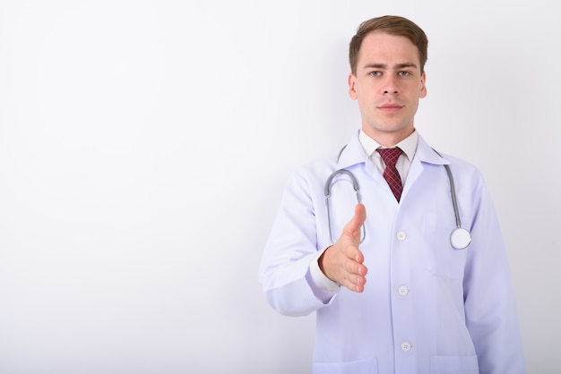 Photo médecin de jeune bel homme sur mur blanc