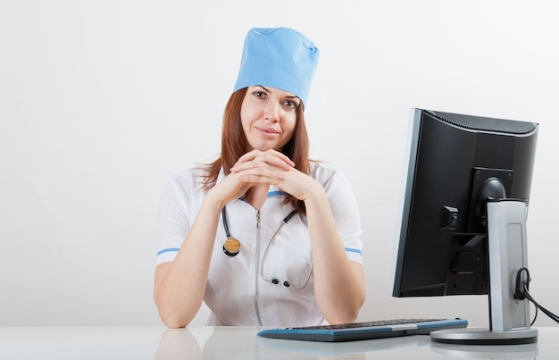 Photo médecin sur un lieu de travail à l'ordinateur