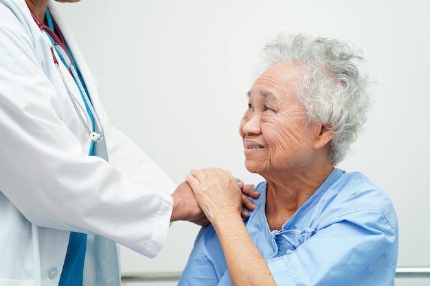 Médecin, main dans la main, femme âgée asiatique, patient, aide et soins à l'hôpital