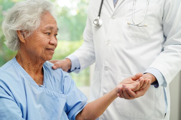 Médecin, main dans la main, femme âgée asiatique, patient, aide et soins à l'hôpital