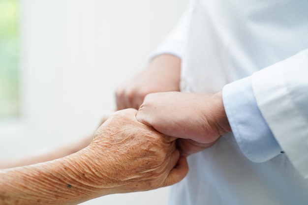 Médecin, main dans la main, femme âgée asiatique, patient, aide et soins à l'hôpital