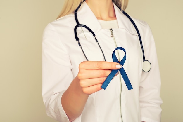 Médecin mains tenant le ruban bleu, le diabète et la sensibilisation au cancer colorectal