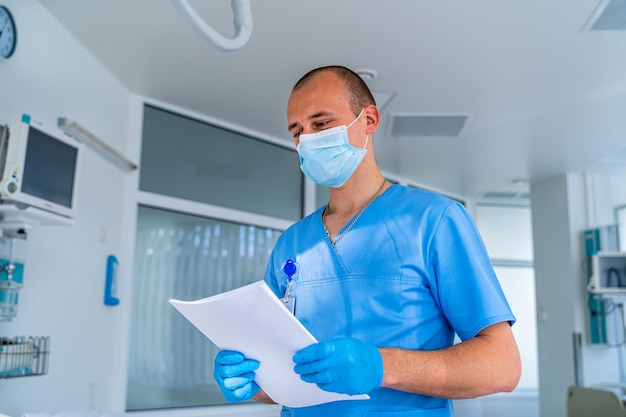 Médecin en masque Chambre moderne spéciale à l'hôpital Lit médical moderne et dispositif spécial dans le service moderne