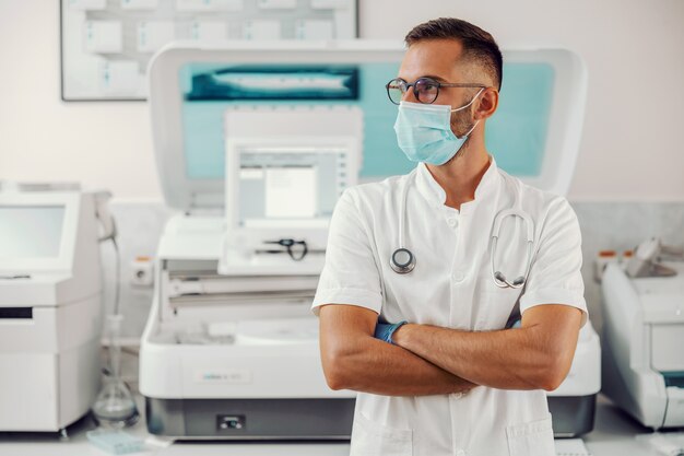 Médecin avec masque facial debout à l'hôpital pendant l'épidémie de virus corona.