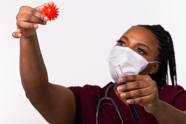 Un médecin en masque de protection médicale détient un modèle de coronavirus