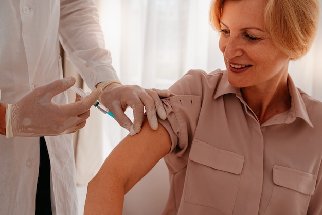 Un médecin avec masque et seringue est prêt à administrer le vaccin contre covid