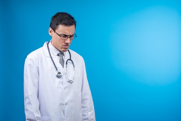 Médecin mécontent avec stéthoscope debout en studio