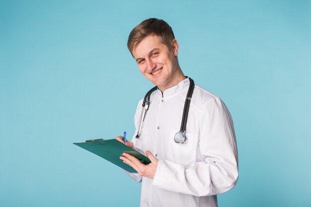 Médecin médecin homme sur fond bleu clinique.