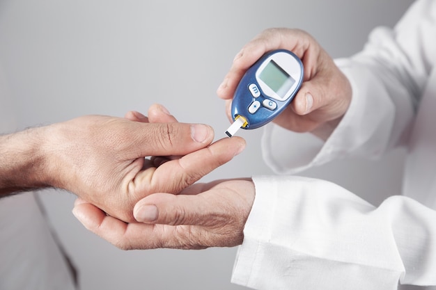 Médecin mesurant le niveau de glucose chez le patient.