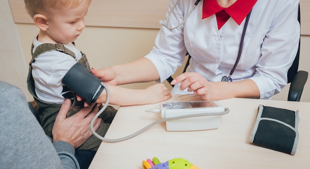 Médecin mesurant la pression artérielle d'un enfant.