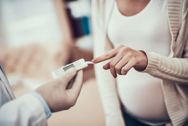 Un médecin mesure la glycémie d&#39;une femme enceinte