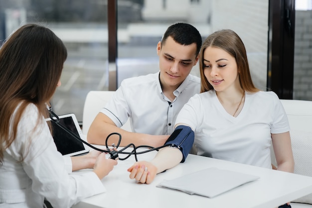 Le médecin mesure la pression d'une fille enceinte à la clinique. Grossesse et soins de santé