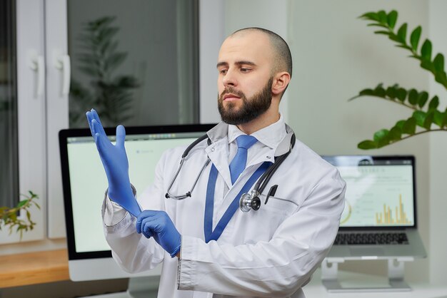 Un médecin met un gant médical jetable
