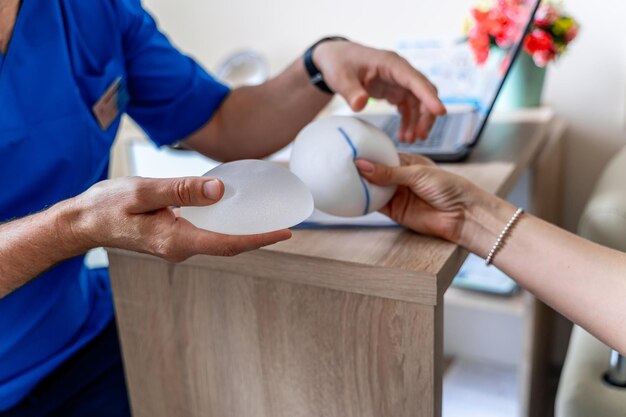 Médecin montrant des implants en silicone. Chirurgie des implants de beauté féminine.