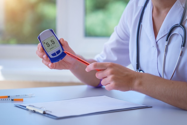 Un Médecin Montre Un Lecteur De Glycémie Avec Une Glycémie à Un Patient Diabétique Lors D'une Consultation Médicale Et D'un Examen à L'hôpital. Mode De Vie Diabétique Et Soins De Santé