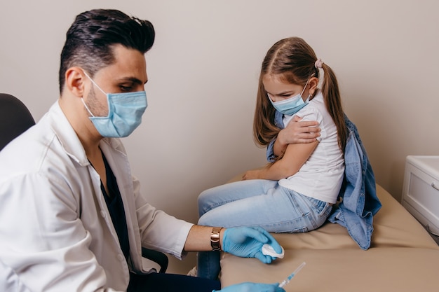 Un médecin de nationalité arabe ou turque a administré à la petite fille un vaccin contre le coronavirus. Les filles sont blessées. Photo de haute qualité