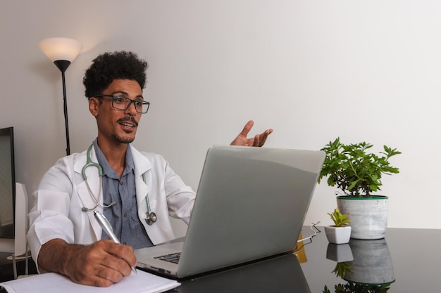 Médecin noir brésilien ou vétérinaire travaillant à la maison jeune homme faisant du bureau à domicile pendant la journée au bureau avec ordinateur portable