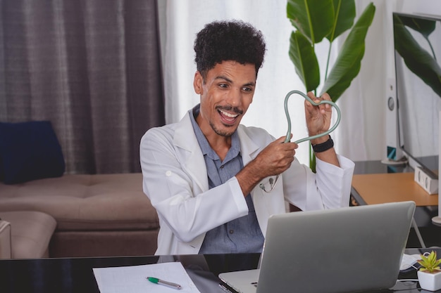 Médecin noir brésilien ou vétérinaire travaillant à la maison jeune homme faisant du bureau à domicile pendant la journée au bureau avec ordinateur portable