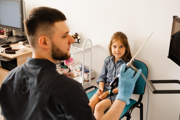 Photo médecin oto-rhino-laryngologiste avec rhinoscope pour endoscopie consultation de l'enfant avant l'endoscopie nasale examen du nez de l'enfant et diagnostic de la maladie