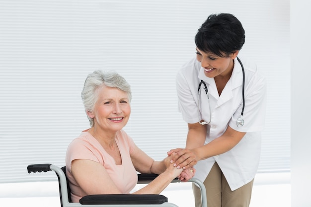 Médecin parlant à un patient senior en fauteuil roulant