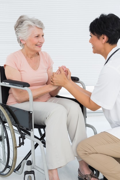 Médecin parlant à un patient senior en fauteuil roulant