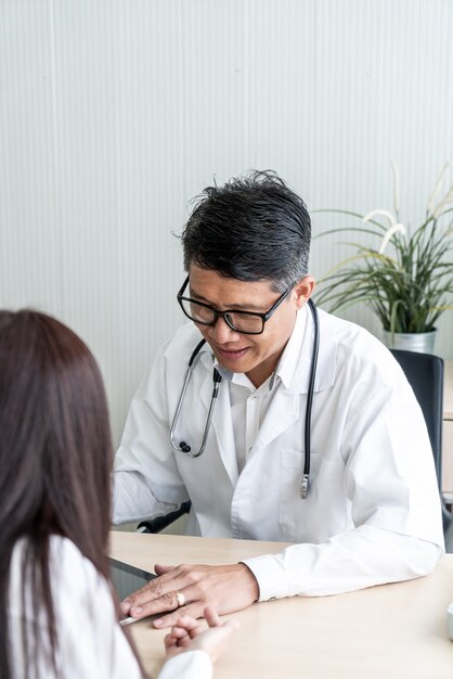 Un médecin et un patient asiatique discutent