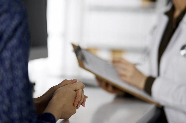 Médecin et patient discutant de l'examen de santé actuel alors qu'ils étaient assis à la clinique. Service médical parfait à l'hôpital. Notion de médecine.