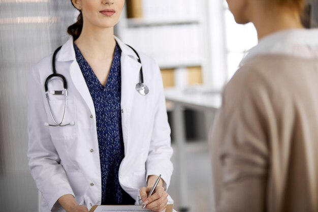 Médecin et patient discutant de l'examen de santé actuel alors qu'ils étaient assis à la clinique. Service médical parfait à l'hôpital. Notion de médecine.