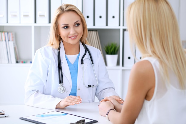 Médecin et patient discutant de quelque chose assis à la table Concept de médecine et de soins de santé