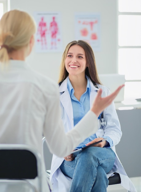 Médecin et patient discutant de quelque chose assis à la table Concept de médecine et de soins de santé