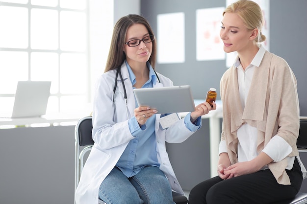 Médecin et patient discutant de quelque chose assis à la table Concept de médecine et de soins de santé