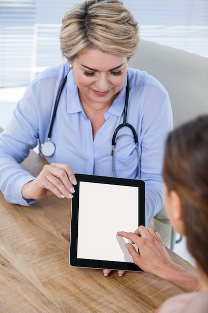 Médecin et patient discutant sur tablette numérique