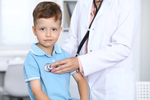 Médecin et patient à l'hôpital Heureux petit garçon s'amusant tout en étant examiné avec un stéthoscope Concept de soins de santé et d'assurance