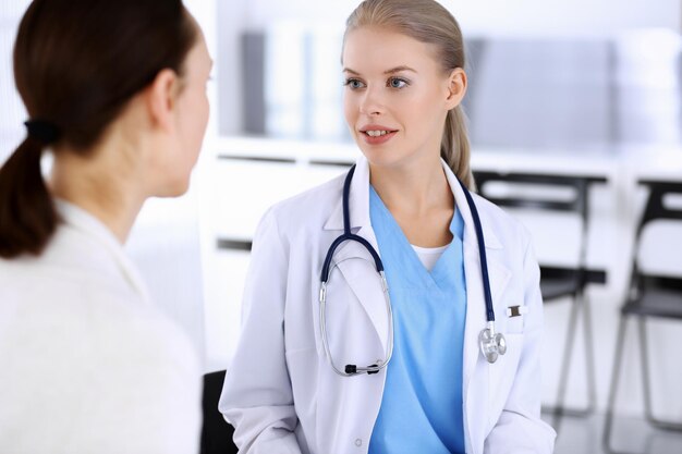 Photo médecin et patient pendant la consultation médecin au travail remplissant l'historique des médicaments alors qu'il était assis dans une séance de portrait d'hôpital d'urgence concept de médecine et de soins de santé