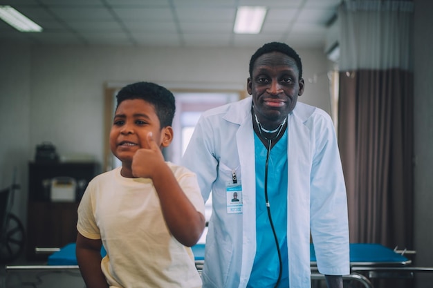 Médecin pédiatre afro-américain avec enfant patient à l'hôpital