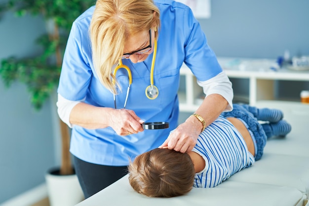 Médecin pédiatre examinant les petits enfants dans la vérification des oreilles de la clinique. Photo de haute qualité