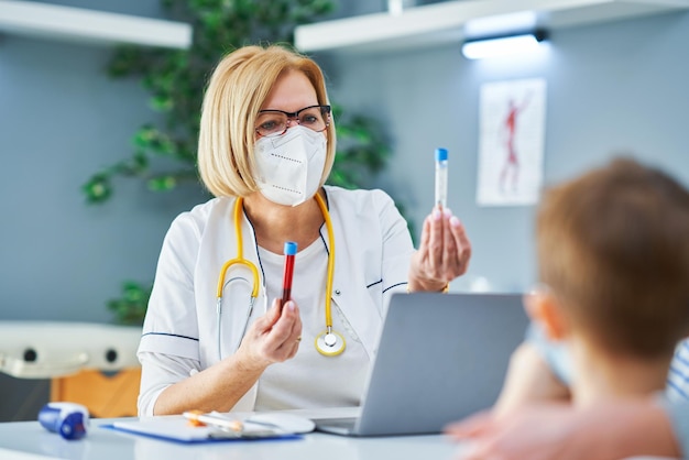 Médecin pédiatre examinant les petits enfants lors d'un test sanguin clinique. Photo de haute qualité