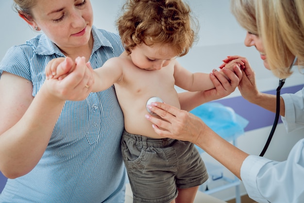 Médecin pédiatre sympathique avec enfant patient à la clinique