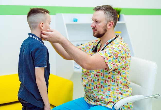 Le Médecin Pédiatre Vérifie Les Ganglions Lymphatiques Du Petit Garçon.