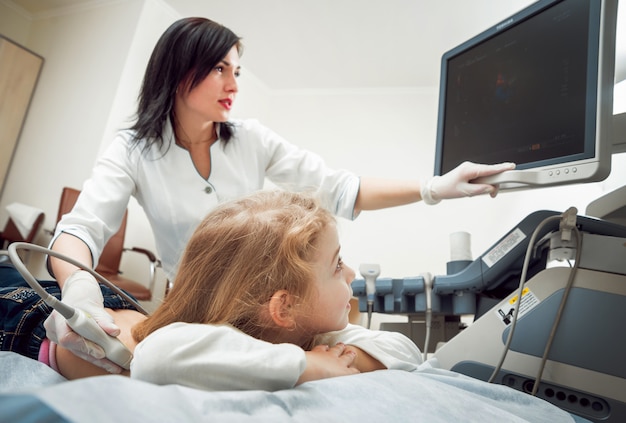 Médecin et petite fille patiente. Matériel d'échographie.