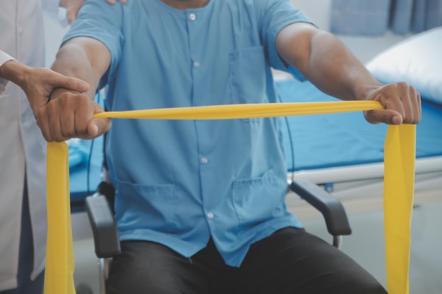 Photo médecin ou physiothérapeute examinant le traitement du bras blessé d'un athlète masculin qui s'étire et fait de l'exercice faire la thérapie de réadaptation douleur en clinique