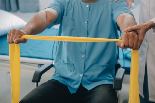 Photo médecin ou physiothérapeute travaillant à examiner le traitement du bras blessé d'un athlète homme patient étirement et exercice effectuer la thérapie de réadaptation de la douleur en clinique