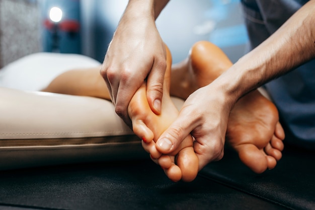 Le médecin-podiatre effectue un examen et un massage du pied du patient à la clinique.