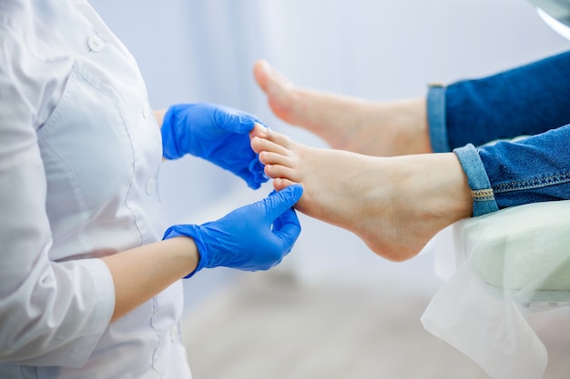 Médecin podiatre examine le pied