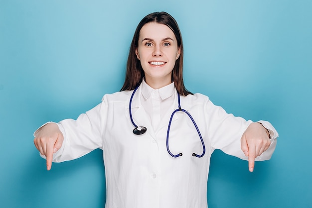 Médecin pointant vers le bas, invitant à un examen, montrant la publicité de l'hôpital