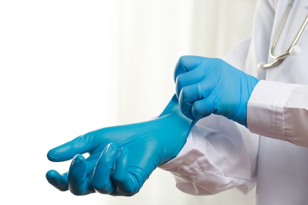 Médecin portant des gants en caoutchouc bleu pour se protéger du COVID-19 à l'hôpital