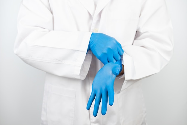 Photo un médecin portant des gants en latex bleu