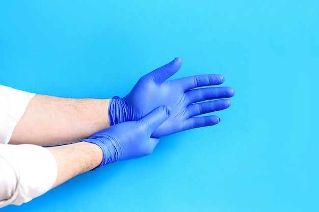 médecin portant des gants de protection bleus.