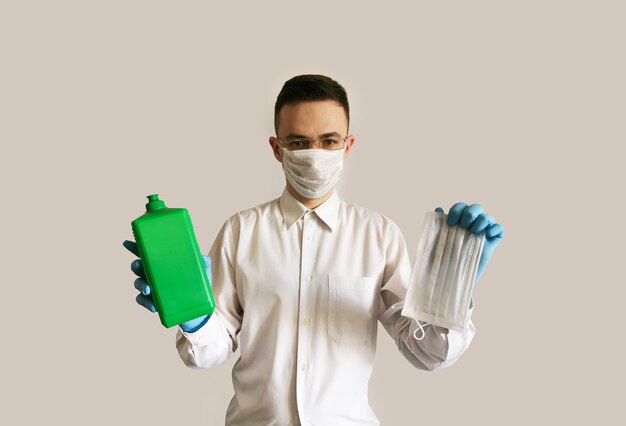 Un médecin portant des lunettes et des gants de masque médical tient un antiseptique et un masque Contexte